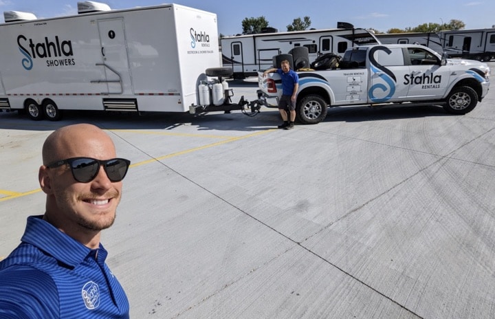 Man taking selfie with Stahla Rentals trucks behind.