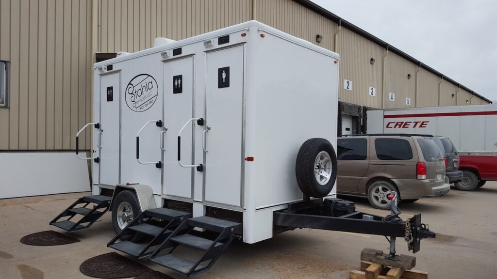 Mobile restroom trailer parked outside building
