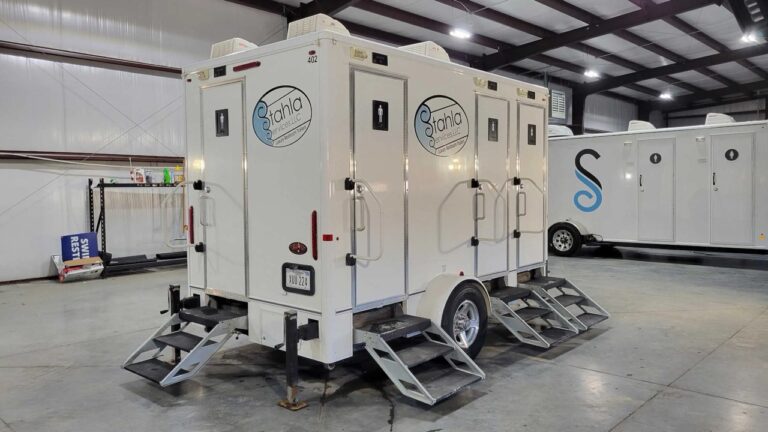 Mobile restroom trailers parked indoors for event rental