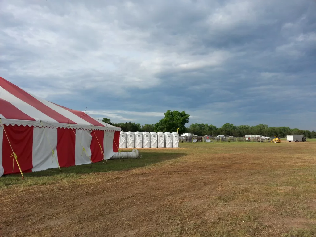 Outdoor event with large red and white tent.
