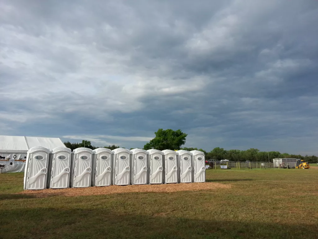 Row of portable toilets at outdoor event.