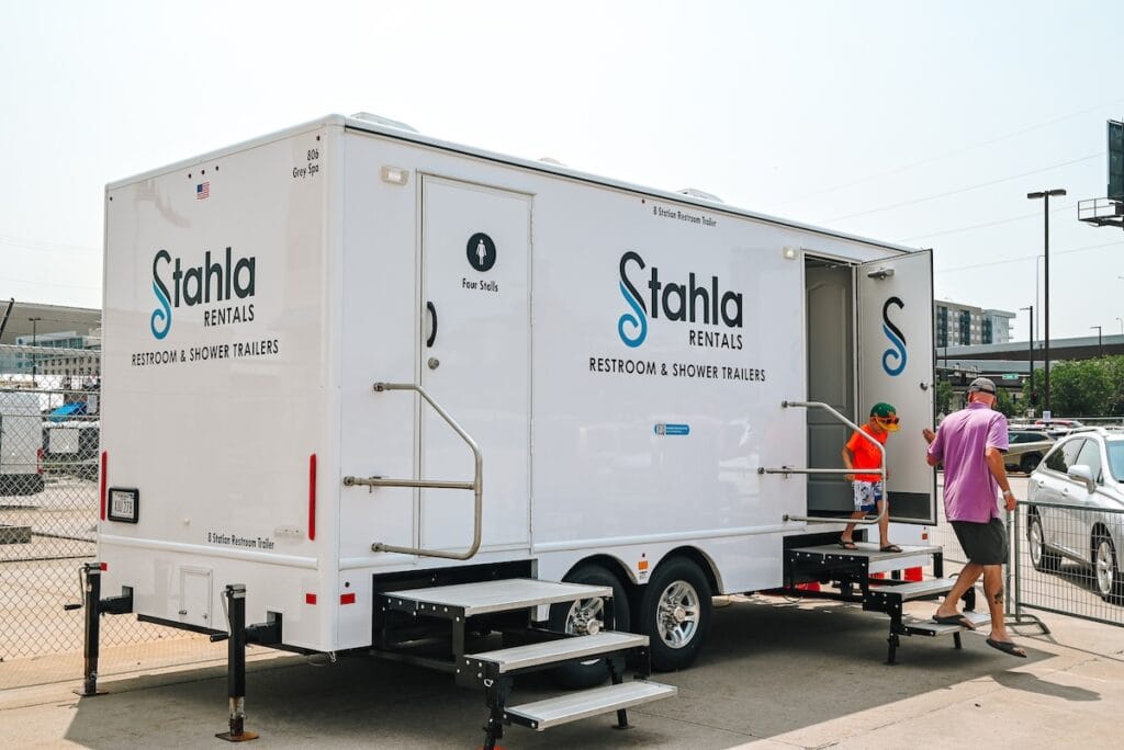Portable 5 Stall restroom trailer with Stahla Services' company branding and people