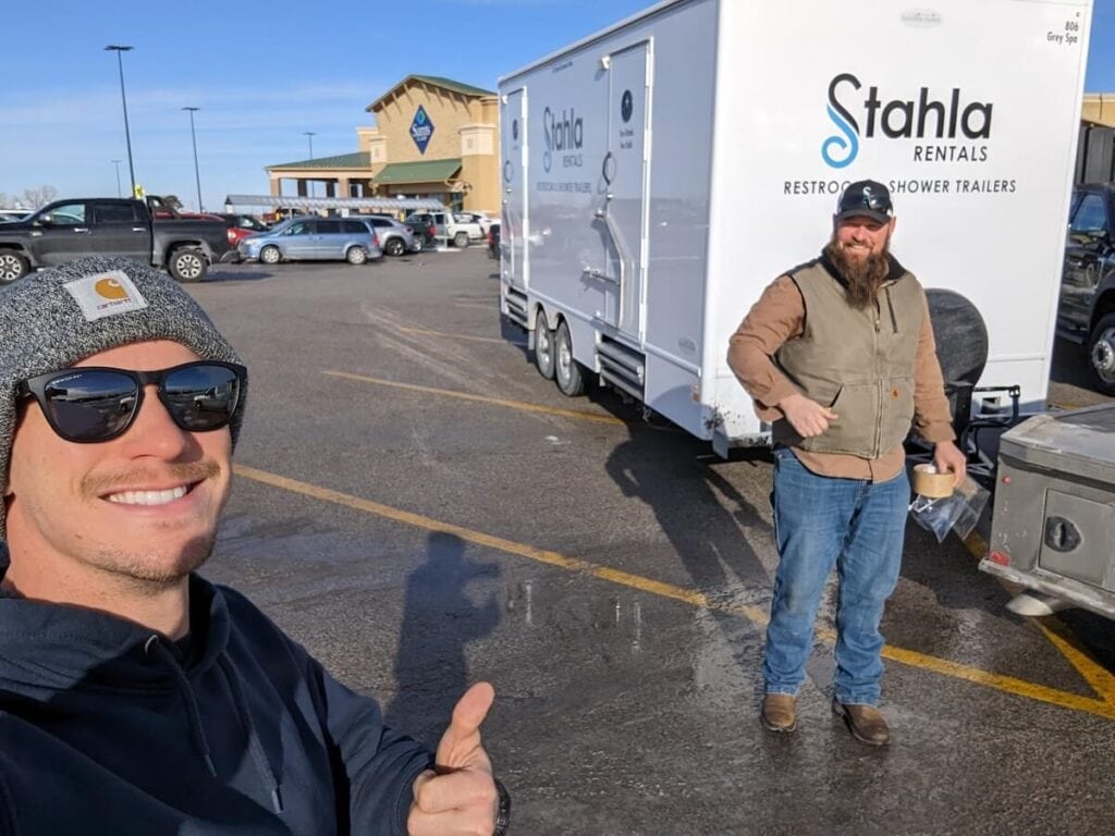 Two men posing with a Stahla Rentals trailer.