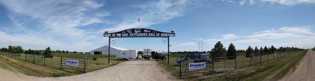 Panoramic view of rural event entrance with archway.